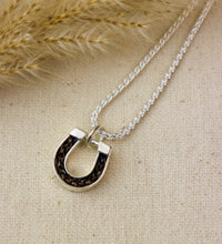 Silver necklace with a unique pendant on a textured beige surface